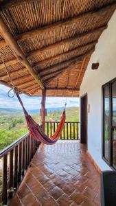 a hammock on a balcony with a view at Hotel AMANEE in Barichara