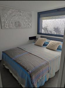 ein Schlafzimmer mit einem Bett mit zwei Kissen und einem Fenster in der Unterkunft L'Orlu Chambres D'Hotes proximité plage in Canet-en-Roussillon
