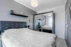 a bedroom with a large bed and a mirror at Central Apartments & Wal25C in Gdańsk