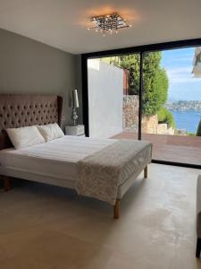 1 dormitorio con cama grande y ventana grande en Villa LA ALEGRIA en Niza