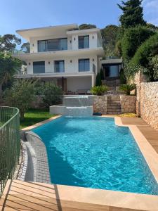 una casa con piscina frente a una casa en Villa LA ALEGRIA en Niza