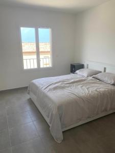 サン・フロランにあるDomaine Amortella Saint-Florentのベッドと窓のある白い寝室