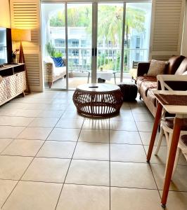 - un salon avec un canapé et une table dans l'établissement Peppers Beach Club Penthouse, à Palm Cove