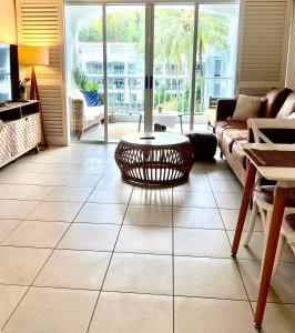 a living room with a couch and a table at Peppers Beach Club Penthouse in Palm Cove