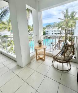 a balcony with chairs and a view of the ocean at Peppers Beach Club Penthouse in Palm Cove