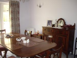 a dining room with a wooden table and a dresser at The Coach House in Shepreth +24 photos