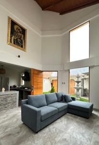 Sacred Valley House في Calca: غرفة معيشة مع أريكة زرقاء ونافذة كبيرة
