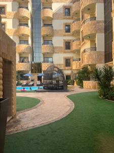 a large apartment building with a courtyard with green grass at EWG Golden Sea Hotel Obhur in Jeddah