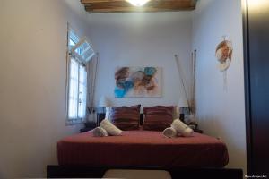 um quarto com uma cama com lençóis vermelhos e uma janela em Villa Alexandra em Exámbela