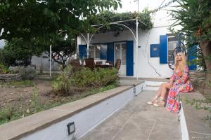 a woman in a dress sitting on a wall at Villa Alexandra in Exámbela