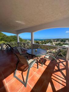 a table and chairs on a balcony with a view at Breathtaking View Villa in Saint Marks Village