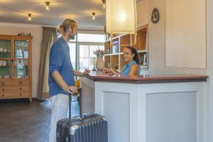 un homme et une femme debout au comptoir avec une valise dans l'établissement Hotel San Telmo, à Santa Cruz de la Palma