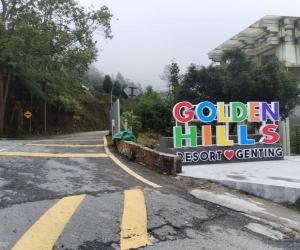 ゲンティンハイランドにあるGolden Hill Resort Genting Highlandの道路横の黄金の丘を読む看板