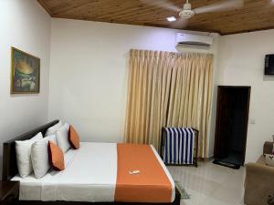 1 dormitorio con 1 cama y TV en una habitación en Paris Garden Resort en Trincomalee