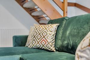 a green couch with two pillows on it at Opulent Contractor Stay in Birmingham