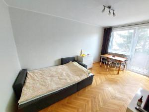 a bedroom with a bed and a table in it at Kawalerka z prywatną łazienką i kuchnią in Gdańsk