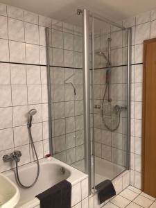 y baño con ducha, bañera y lavamanos. en Eifelpause, en Plaidt