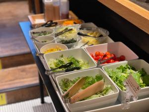 東京にある変なホテル東京西葛西のサラダと野菜のトレーが並ぶテーブル