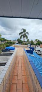 a large swimming pool with blue tables at Casa de Praia C/Piscina Matinhos 15 Pessoas 450m do Mar in Matinhos
