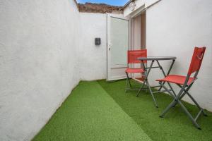 two chairs and a table on a patio with grass at L'Evasion Amboise, Sauna Jacuzzi in Amboise