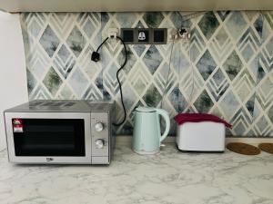 a microwave sitting on a counter next to a toaster at Sehijau Homestay Kangar in Kangar