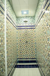 a bathroom with a tiled wall with a shower at Bulvar Inn Baku Hotel in Baku