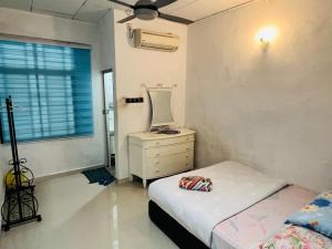 a bedroom with a bed and a dresser with a mirror at Sehijau Homestay Kangar in Kangar