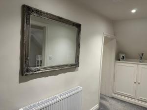 uno specchio sulla parete di una stanza con termosifone di Hudson Apartment - 2 bedroom, Oakham Centre by Belmont Places a Oakham