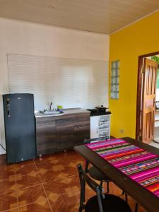 uma cozinha com um frigorífico preto e uma mesa em Casapreciosa-LasLajas em Las Lajas