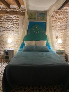 A bed or beds in a room at Aux quatre coins du monde