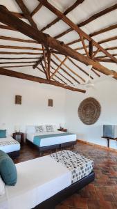 two beds in a room with wooden ceilings at Hotel AMANEE in Barichara
