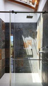 a shower with a glass door in a bathroom at Hotel AMANEE in Barichara