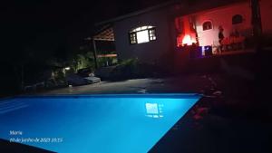 uma casa com piscina à noite em casa rosa em Cotia