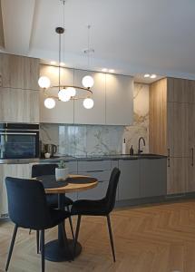 a kitchen with a table and chairs in a room at Apartments with an impressive terrace on the roof of the house in Vilnius