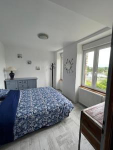 a bedroom with a bed and a clock on the wall at La maison du lac in Saint-Hilaire-du-Harcouët