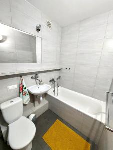 a bathroom with a toilet and a sink and a tub at Kawalerka z prywatną łazienką i kuchnią in Gdańsk