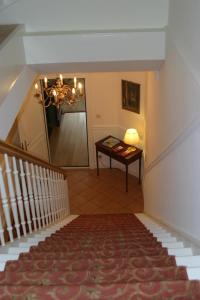 un couloir avec une table, un miroir et un escalier dans l'établissement Landhaus Bode, à Travemünde