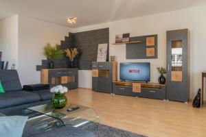 a living room with a couch and a tv at CloudCabins No 1 - Traumblick im Herzen des Schwarzwaldes in Dornstetten