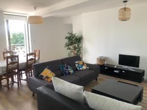 a living room with a couch and a table at La maison du lac in Saint-Hilaire-du-Harcouët