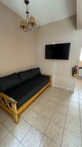 un soggiorno con divano e TV a schermo piatto di Casa Tilo a El Bolsón