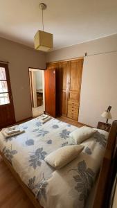 a bedroom with a large bed with a blue and white blanket at Casa Tilo in El Bolsón