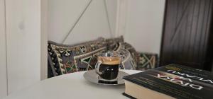 un libro y una copa de café en una mesa con un libro en Apartmán Spálený mlýn, en Líšnice
