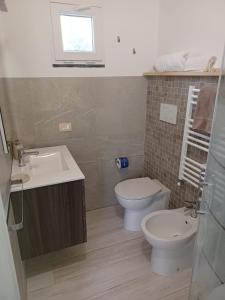 łazienka z umywalką, toaletą i oknem w obiekcie B&B DORMO AL MARE w mieście Savio di Ravenna