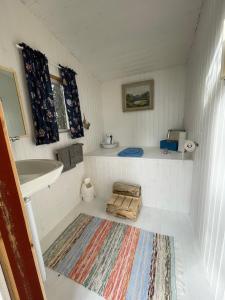 a small bathroom with a sink and a rug at Pine Tree Cabin in Glommersträsk