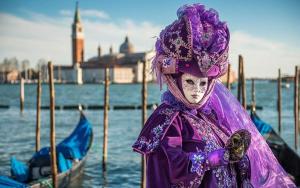 a person dressed up in a purple costume standing next to a boat at Palm beach appartment 80 mt dal mare e comodo per Venezia in Lido di Jesolo