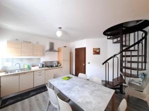 a kitchen with a dining table and a spiral staircase at Appartamento grande Al Ponte. Situato vicino all'ospedale, al parco e al centro città in Trento