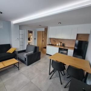 a kitchen and living room with a table and a couch at Apartament Wiktoria in Kluszkowce