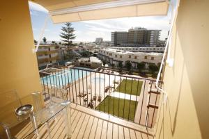 balcón con vistas a la piscina en Fantastic apartment with sea views, en Playa del Inglés