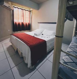 een slaapkamer met een bed en een stapelbed bij Hotel Morada de Leste in Pontal do Paraná