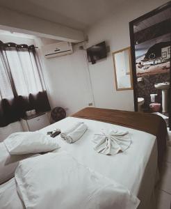 ein Schlafzimmer mit einem weißen Bett mit zwei Handtüchern darauf in der Unterkunft Hotel Morada de Leste in Pontal do Paraná